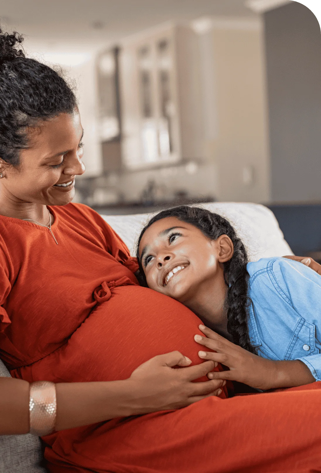 child listening to expectant indian mother's belly